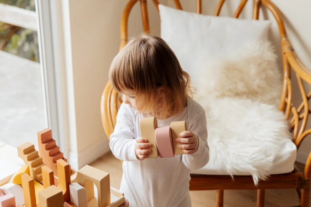 adorable kid playing with wooden construction blocks 3933022 scaled