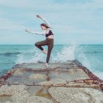 woman doing ballet pose on the breakwater with waves 3049220